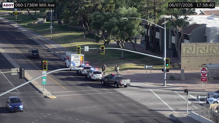Multiple police vehicles and two individuals in the right lane