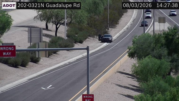 Dark SUV with driver's door open on the right shoulder
