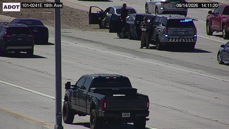 State Trooper vehicle with blue lights on the shoulder next to a stopped car