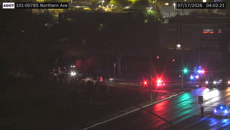 Two police cars with red and blue lights on the roadway