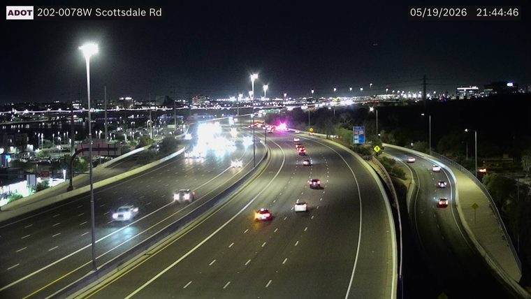 Emergency vehicle with flashing lights on the left shoulder in the distance