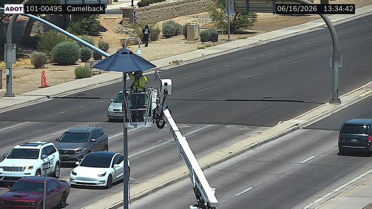 Construction worker in bucket lift over the roadway