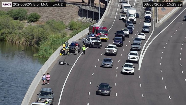 Motorcycle on its side in the left lane with responders present