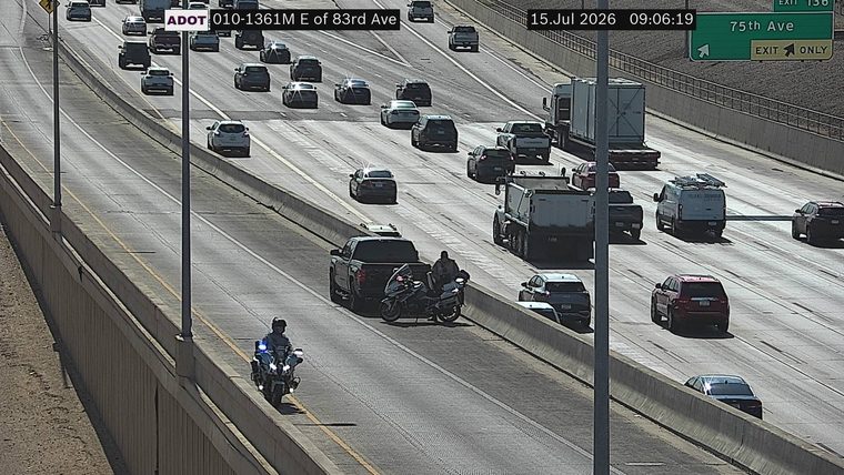 Police motorcycle with lights on near a pickup truck and another motorcycle