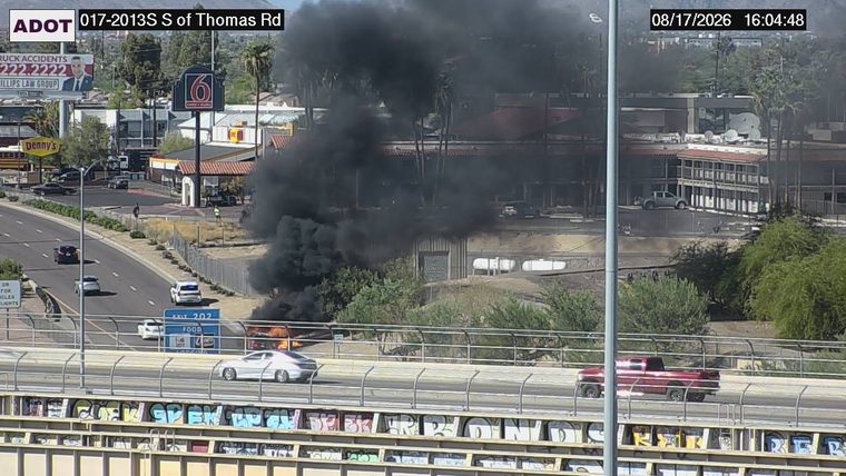 Vehicle on fire with heavy black smoke in the right lane