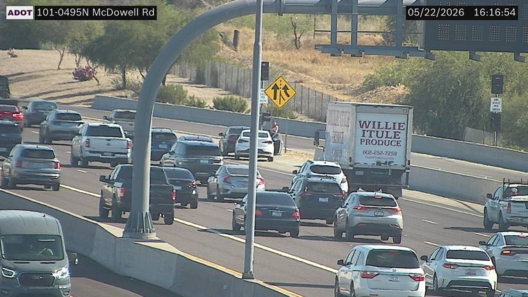 White SUV on the right shoulder with a person standing outside next to it