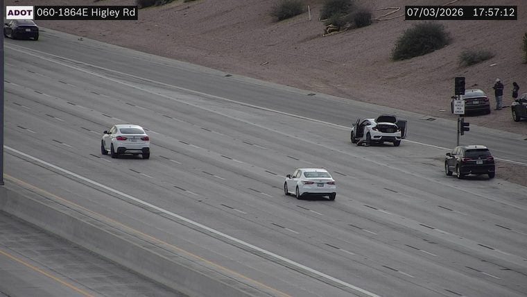 White sedan with open doors and trunk on the right side of the roadway