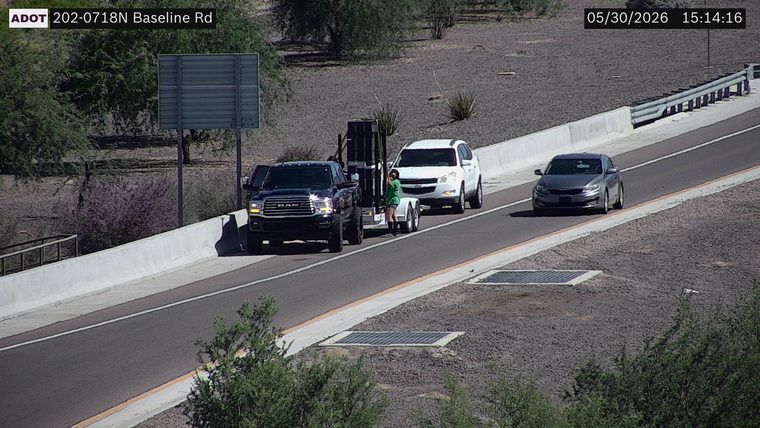 Person standing next to a trailer in the right lane