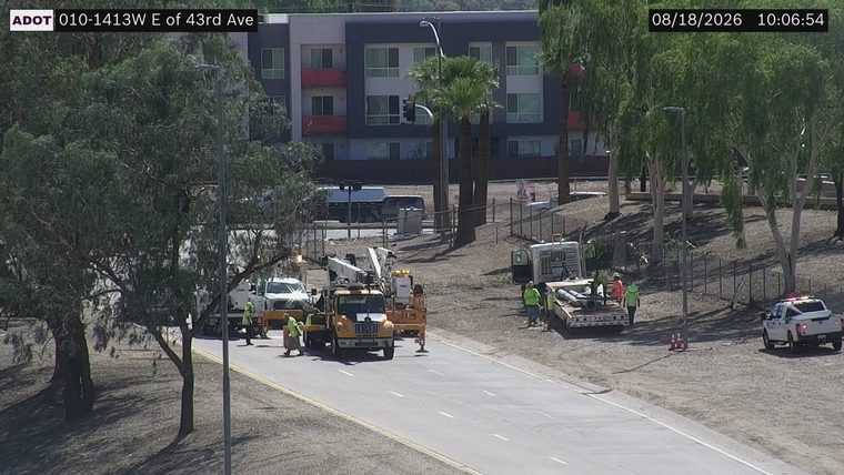 Construction crew with equipment and vehicles on the side of the road