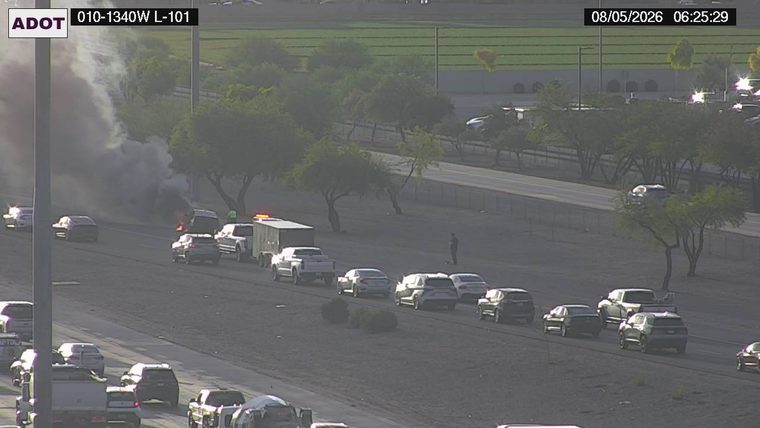Vehicle on fire with smoke in the left lane