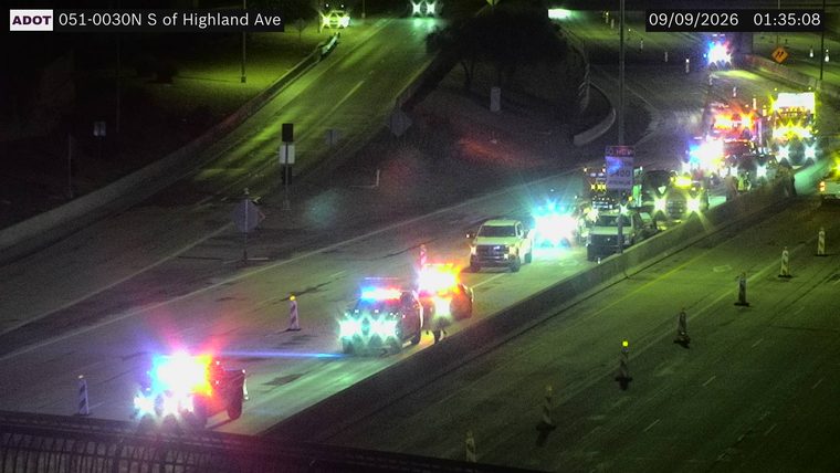 Multiple emergency vehicles with red and blue lights on the right shoulder