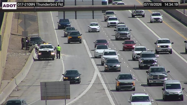 Tow truck and police car with lights on the shoulder
