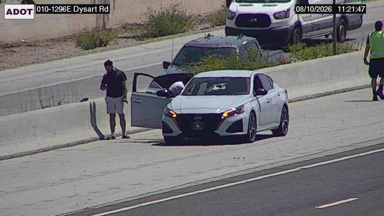 Person standing on the left shoulder next to an open car door