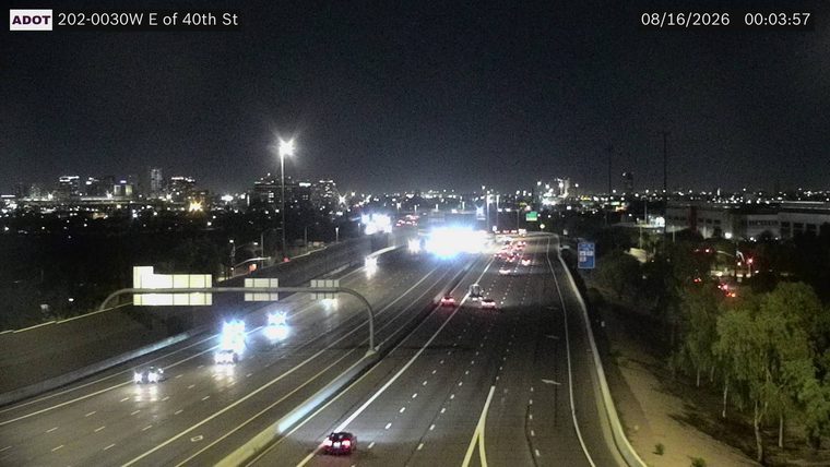 Two police cars with flashing lights on the left shoulder