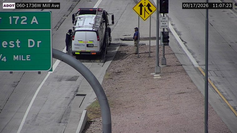 Two workers near a service truck on the right shoulder