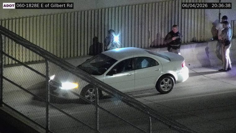 Three persons and a white car on the right shoulder