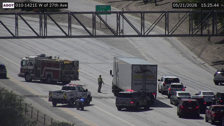 Multiple emergency responders, including a fire truck, ADOT response vehicle, state trooper SUV, and a responder on foot, blocking lanes on the highway