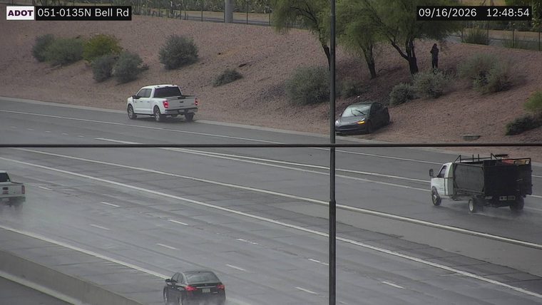 Dark sedan partially off the roadway on the right shoulder