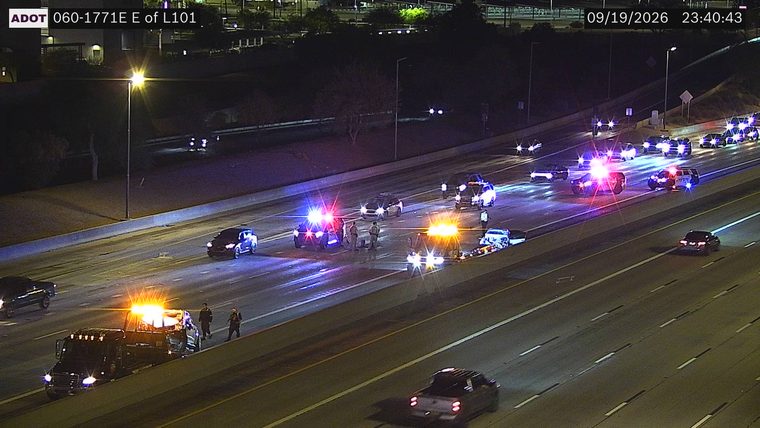 Multiple police cars and tow trucks with flashing lights in multiple lanes