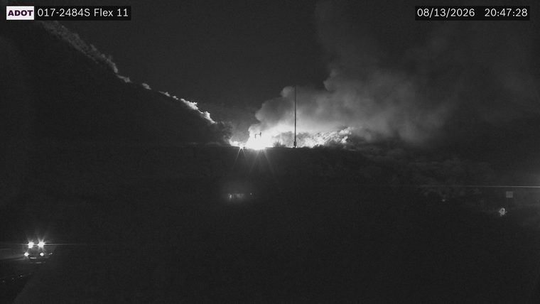 Large plume of smoke and flames visible over the horizon
