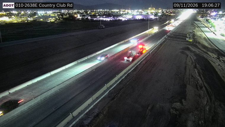 Truck with red and blue flashing lights on the right shoulder