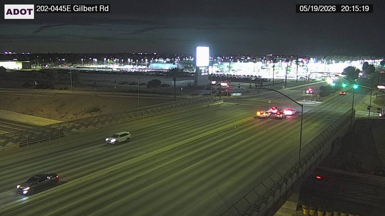 Multiple emergency responder vehicles with flashing lights stopped in the right lanes near the exit