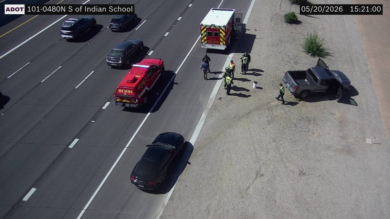 Emergency responders, an ambulance, and a fire command vehicle on the right shoulder next to a pickup truck with open doors