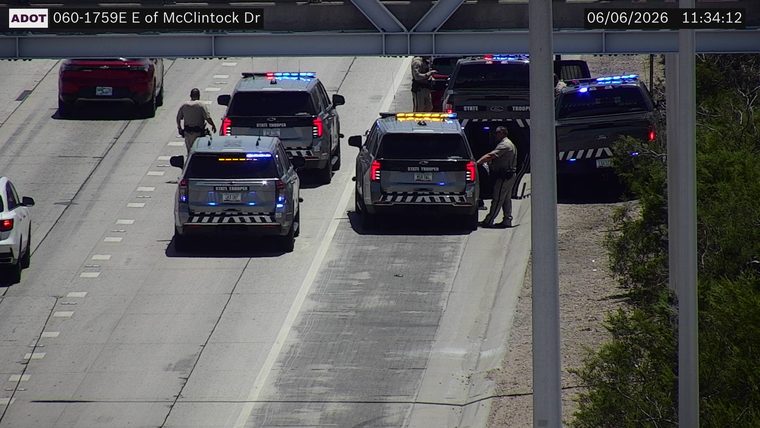 Multiple state trooper vehicles with lights on in the right lane and on the shoulder