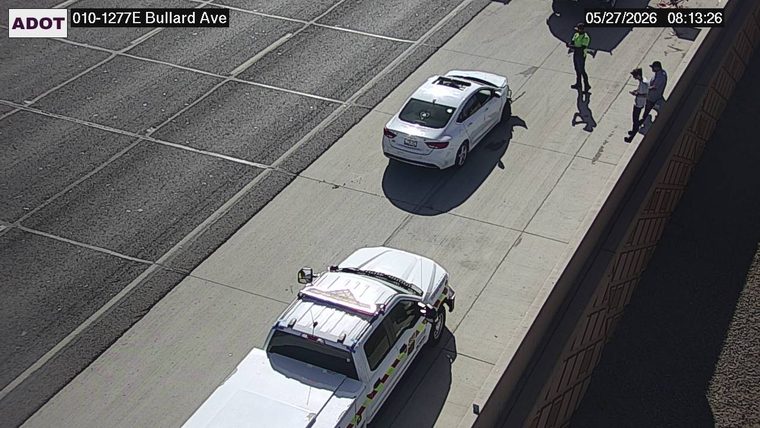 ADOT response vehicle and a white sedan on the right shoulder with three people standing nearby, including a responder in a high-visibility vest