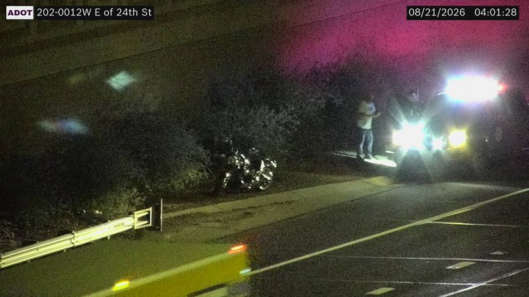 Motorcycle on the shoulder next to a police vehicle with lights on