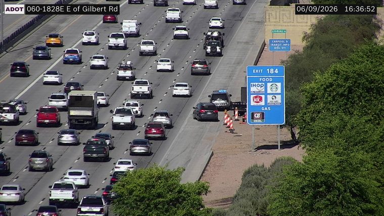 Construction cones and a police vehicle on the right shoulder