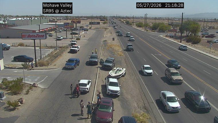 Two vehicles and a boat trailer pulled over on the right shoulder