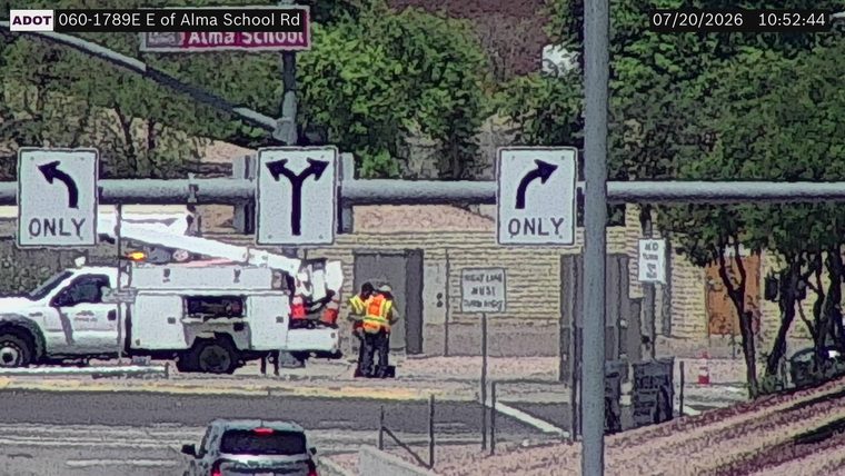 Two workers in high-visibility vests near a utility truck