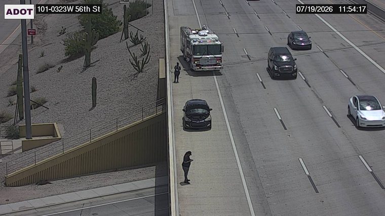 Fire truck with two people standing near it on the shoulder