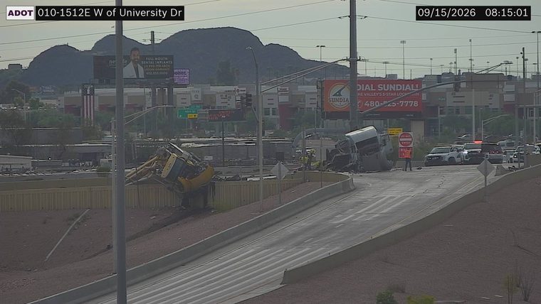 Tractor-trailer overturned and off the roadway, with a construction vehicle also overturned nearby