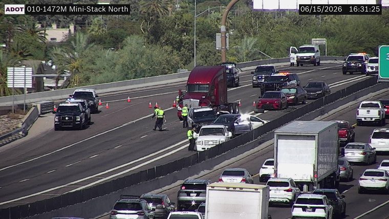 Multiple police vehicles and personnel attending to a multi-vehicle incident in the left lanes
