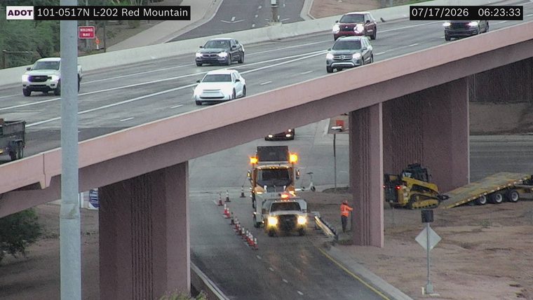 Tow truck with amber lights and traffic cones in the right lane