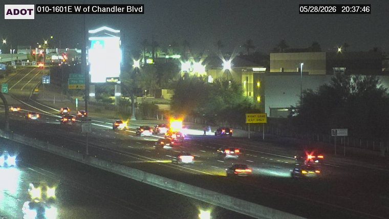 Flashing lights and two people standing in the right lane