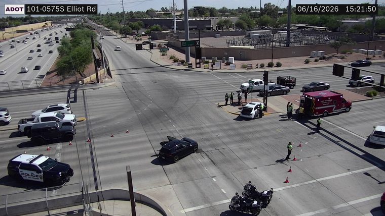 Ambulance and police officers at intersection with two vehicles involved