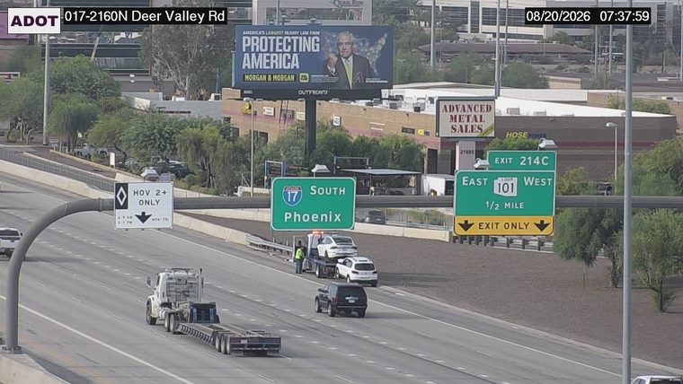 Tow truck with two vehicles on it on the right shoulder