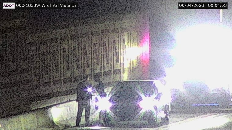 Person standing next to a vehicle with flashing lights