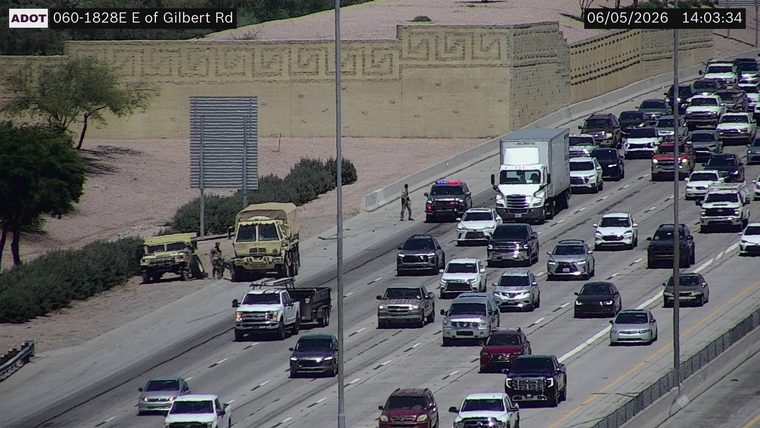 Police car with lights on in the left lane