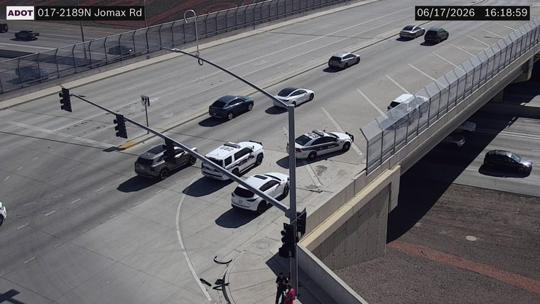 Two police cars and a white SUV stopped in the roadway