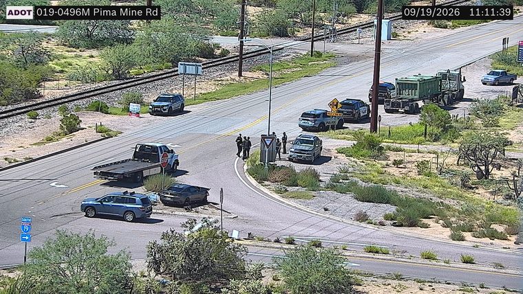 Several police officers gathered around a vehicle in the intersection