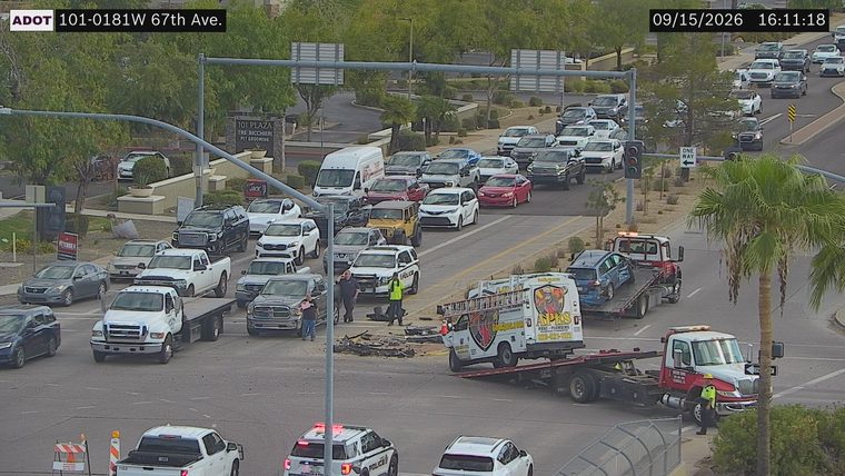 Debris in the intersection and two tow trucks with damaged vehicles