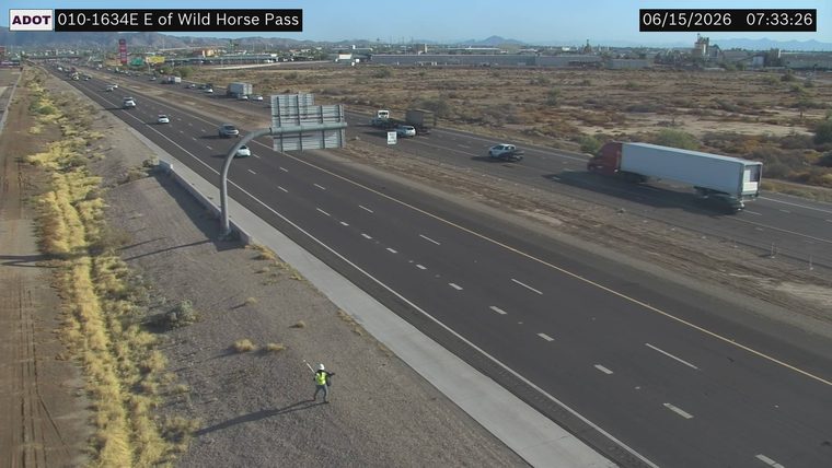 Worker with reflective vest and hard hat on the shoulder