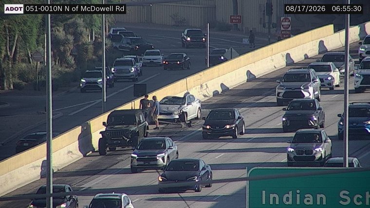 Silver sedan with visible front-end damage in the middle lane