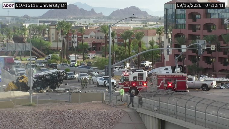 Tractor-trailer overturned across multiple lanes with visible damage, fire department vehicles present