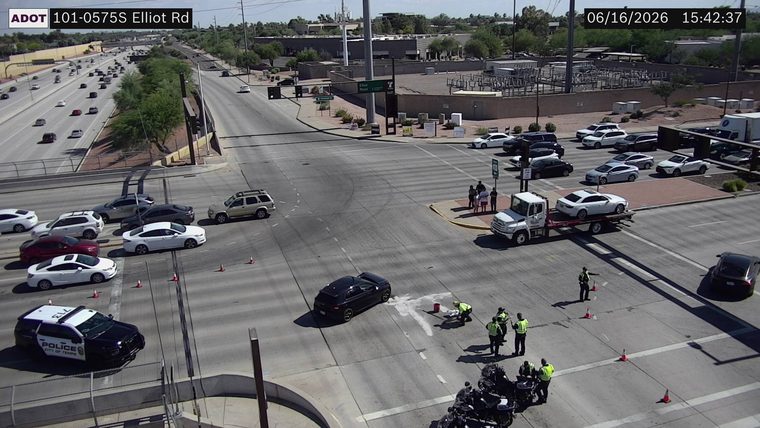 Several people in high-visibility vests attending to a spill in the intersection