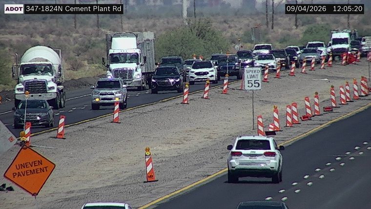 Orange "Uneven Pavement" sign and traffic cones in the right lane